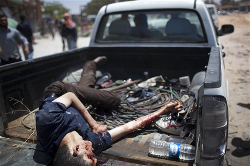 A dead rebel fighter lis carried in a pick up at the front line between them and Moammar Gadhafi forces, 25 km west from Misrata, Libya, Thursday, May 26, 2011.  The deputy leader of Libya's rebel administration said it could take up to two years to organize elections, backtracking on promises of a six-month transition to democracy and adding to internal dissent already brewing within the movement seeking to topple Moammar Gadhafi. (AP Photo/Rodrigo Abd) (AP)