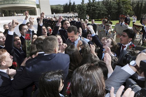 In this photo released by the Syrian official news agency SANA, Syrian students shout supportive slogans to Syrian President Bashar Assad, center, as he arrives to lay a wreath at the tomb of the unknown soldier during Martyrs day in Kasiyoun mountain in Damascus, Syria, Friday, May 6, 2011. Syrian activists say security forces are taking strict measures around the country as anti-regime protesters prepare for a new day of demonstrations. (AP Photo/SANA) EDITORIAL USE ONLY (AP)