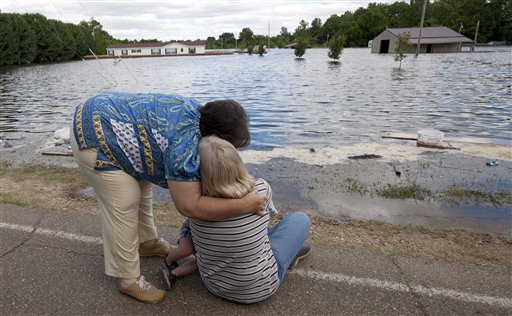 Brenda Hynum, left,  hugs her daughter Debra Emery as she watches floodwaters rise around her mobile home in Vicksburg, Miss., Monday, May 16, 2011. A sand berm they built around their trailer failed in the night and floodwaters from the rising Mississippi river rushed in. "We tried so hard to stop it. It goes from anger to utter disbelief that this could happen. I just want to go home." Emery said. (AP Photo/Dave Martin) (AP)