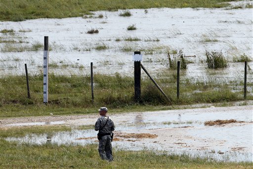 A member of the Louisiana National Guard stands guard as water diverted from the Mississippi River through a bay in the Morganza Spillway begins to fill a pasture in Morganza, La., Saturday, May 14, 2011.   Opening the Morganza spillway diverts water away from Baton Rouge and New Orleans, and the numerous oil refineries and chemical plants along the lower reaches of the Mississippi. (AP Photo/Patrick Semansky) (AP)