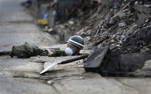 A Japan Ground Self-Defense Force soldier works in a sewer in an area devastated by the March 11 earthquake and tsunami in Taro, Iwate Prefecture, northeastern Japan, Friday, May 13, 2011. (AP Photo/Junji Kurokawa) (AP)