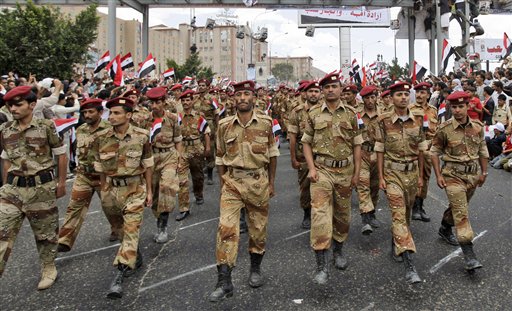 Yemeni army soldiers who joined the anti-government protestors , march during a ceremony to commemorate the anniversary of Yemen's reunification, in Sanaa, Yemen, Sunday, May 22, 2011. A deal for Yemeni leader Ali Abdullah Saleh to step down after 32 years in power was thrown into doubt Sunday after the ruling regime brought hundreds of loyalists into the streets to protest the pact and said he would not sign unless a public ceremony were held that included opposition leaders. (AP Photo/Hani Mohammed) (AP)