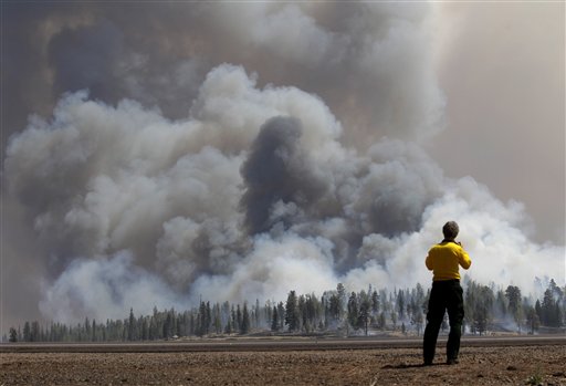 A photographer looks at smoke from a burnout fire as firefighters battle the Wallow Fire in the Apache-Sitgreaves National Forest, Ariz., Sunday, June 12, 2011. Roughly 7,000 residents of two eastern Arizona towns evacuated last week as a wildfire loomed nearby were allowed to return home Sunday as officials expressed confidence that they were making progress in their battle against the huge blaze that has been burning since May. (AP Photo/Jae C. Hong) (AP)