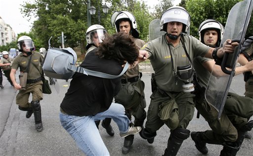 Police arrest a demonstrator trying to block the road to the Parliament during a rally against plans for new austerity measures, in central Athens, Wednesday, June 15, 2011. A 24-hour anti-austerity strike by Greece's largest labor unions crippled public services Wednesday, as the Socialist government was to begin a legislative battle to push through last-ditch cost-cutting reforms that will extend beyond its own term in office. (AP Photo) (AP)
