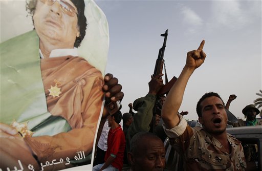 A  Libyan man shouts as he and others rally next to Moammar Gadhafi's Bab al-Aziziya compound, a regular target of NATO airstrikes, in Tripoli, Libya, on Tuesday, June 7, 2011. Gadhafi has vowed to fight to the death in a surprise speech during the heaviest day of NATO shelling in the capital Tripoli. Gadhafi's voice suddenly emerged on Libyan television Tuesday afternoon _ barely an hour after the last of some 30 NATO strikes pounded the capital.  He vowed "We will not kneel" and "We will not surrender!" (AP Photo/Ivan Sekretarev) (AP)