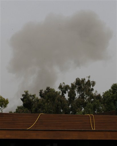 A smoke plume rises into the sky over Tripoli, Libya, on Tuesday, June 7, 2011 following an airstrike. Low-flying NATO military craft have struck seven times in loud, banging succession over the Libyan capital Tripoli. The strikes occurred Tuesday morning, marking an increase in NATO pressure on the regime of Moammar Gadhafi. (AP Photo/Ivan Sekretarev) (AP)