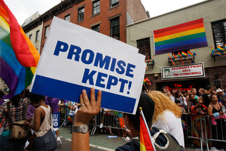 A participant in the Gay Pride Parade marches past the Stonewall Inn in New York on June 26.