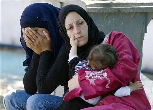 A Syrian refugee mother feeds her baby as another covers her face, in a makeshift hospital in a newly opened refugee camp in the Turkish town of Yayladagi in Hatay province, Turkey, Wednesday, June 22, 2011. The U.N. refugee agency said that 500 to 1,000 people a day have been crossing from northern Syria into Turkey since June 7, and more than 10,000 were being sheltered by Turkish authorities in four border camps(AP Photo/Burhan Ozbilici) (AP)