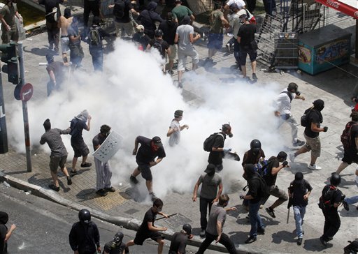 Demonstrators run away from tear gas  during a demo in Athens on Tuesday June 28, 2011. Greece's beleaguered government is bracing for a 48-hour general strike as lawmakers debate a new round of austerity reforms designed to win the country additional rescue loans needed avoid bankruptcy.(AP Photo/Dimitri Messinis) (AP)