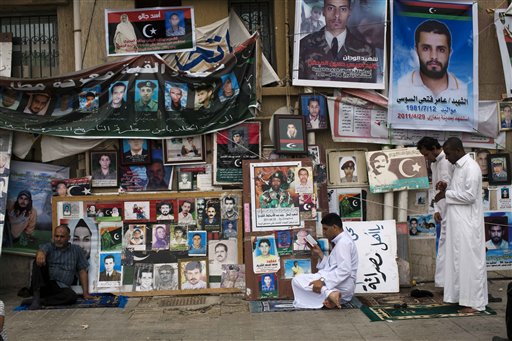 Men pray next to portraits of people killed or who disappeared during the rule of Libyan leader Moammar Gadhafi's regime during Friday prayers in Benghazi, Libya, June 3, 2011.  (AP Photo/Rodrigo Abd) (AP)