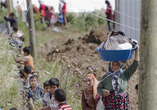 A Syrian refugee woman brings laundry to an irrigation canal in a camp, in Boynuyogun, Turkey, Tuesday, June 14, 2011. According to the Turkish Prime Minister's office the number of Syrian refugees in Turkey stands at more than 8.500 people.As the government expands its crackdown on dissent, activists report tanks entering the northern town of Maaret al-Numan on Tuesday and other villages near Jisr al-Shughour.(AP Photo/Vadim Ghirda) (AP)