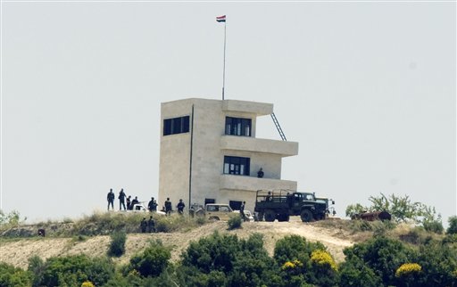 Syrian troops arrive at a hill overlooking Turkey-Syria border, about three kilometers inside Syria, as Syrians waiting to enter Turkey rushed to the crossing point near the Turkish village of Guvecci in Hatay province, Turkey, Thursday, June 23, 2011. Syrian activists claimed that troops backed by tanks and snipers have entered a village along the Turkish border as the regime expands its crackdown on a pro-democracy movement that has posed the gravest challenge to President Bashar Assad's rule(AP Photo/Burhan Ozbilici) (AP)