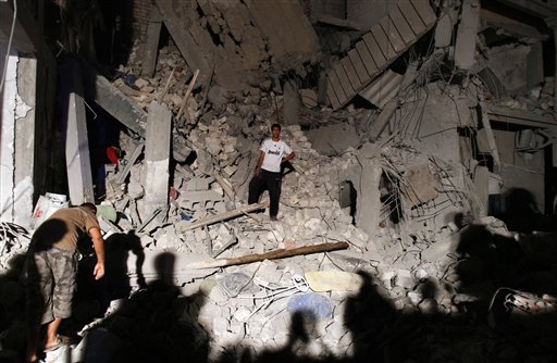 In this photo taken on a government-organized tour, Libyan man stands in debris from a damaged residential building in Tripoli's outskirts, Libya, on Sunday, June 19, 2011. The Libyan government says civilians have been killed in a NATO airstrike that has struck the residential neighborhood in Tripoli.  (AP Photo/Ivan Sekretarev) (AP)