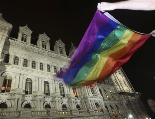 Robert Moore of New York waves a Pride flag outside the Capitol in Albany, N.Y., after the state Senate passed a bill legalizing same-sex marriage, on Friday, June 24, 2011.  (AP Photo/Mike Groll) (AP)