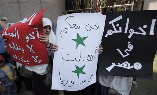 Muslim Brotherhood female supporters hold banners with colors of the Syrian independence flag with Arabic that reads "Your brothers in Egypt, we support our people in Syria, Muslims support Muslims to relieve them from injustice",  during an anti-Syrian President Bashar al-Assad's regime in Cairo, Egypt Friday, June 24, 2011. Egypt's Muslim Brotherhood supporters gathered near the Syrian embassy in Cairo following the weekly Friday prayers chanting anti-Syrian regime. (AP Photo/Nasser Nasser) (AP)