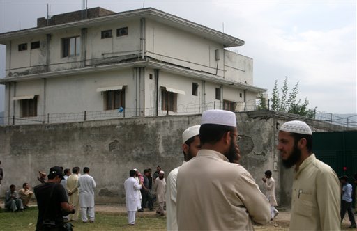 FILE - In this May 5, 2011 file photo, local residents and media are seen outside the house where al-Qaida leader Osama bin Laden was caught and killed in Abbottabad, Pakistan. The courier who led U.S. intelligence to bin Laden's hideout in Pakistan hailed from the Swat Valley, a one-time stronghold of militant Taliban fighters, Pakistani officials said on Wednesday, June 1, 2011. The officials identified the courier as Ibrahim Saeed Ahmed. He and his brother Abrar were shot dead in the daring U.S. Navy SEAL raid May 2 that also killed bin Laden and two other people. (AP Photo/Aqeel Ahmed, File) (AP)