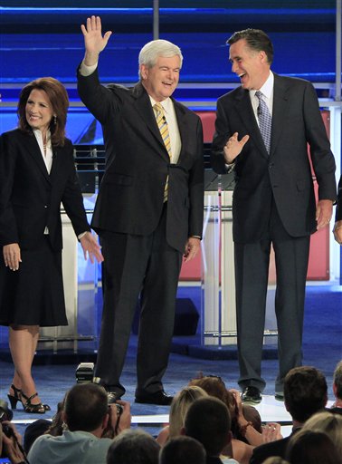 Former Massachusetts Gov. Mitt Romney, right, and former House Speaker Newt Gingrich share a laugh as they wave before the first New Hampshire Republican presidential debate at St. Anselm College in Manchester, N.H., Monday, June 13, 2011. Rep. Michele Bachmann, R-Minn., is at left. (AP Photo/Jim Cole) (AP)