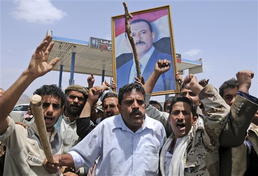 Supporters of Yemeni President Ali Abdullah Saleh hold up his portrait and chant slogans as they celebrate news that Saleh's health is stable, after being taken to Saudi Arabia to receive medical treatment for wounds he suffered in a rocket attack on his compound, in Sanaa, Yemen, Thursday, June 9, 2011. Government troops trying to recapture areas held by Islamic militants have killed 12 suspected al-Qaida members in the troubled southern province of Abyan, the Defense Ministry said Thursday. (AP Photo/Mohammed Al-Sayaghi) (AP)
