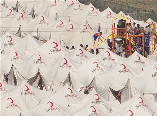 Syrian refugees  children crowd a playing area in a camp in Boynuyogun, near  the Syrian border, Thursday, June 16, 2011. At least 150 more refugees crossed into Turkey on Thursday afternoon, increasing the number of refugees to more than 9,000. They were quickly ferried to the refugee camp in the town of Yayladagi.  Angelina Jolie, the Hollywood celebrity and goodwill ambassador for the U.N. High Commissioner for Refugees is expected to visit the refugees in Turkey on Friday afternoon, the UNHCR said Thursday.(AP Photo/Vadim Ghirda) (AP)