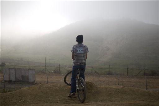 A Druze boy looks at Syria along the border between Israel and Syria near the village of Majdal Shams in the Golan Heights early Monday, June 6, 2011. Israeli troops are bracing for more border violence after a day of deadly clashes with pro-Palestinian protesters who tried to surge into the Israeli-controlled Golan Heights from Syria. Several dozen demonstrators were camped out on the Syrian side of the border overnight, but the Israeli military says all was quiet early Monday. (AP Photo/Ariel Schalit) (AP)