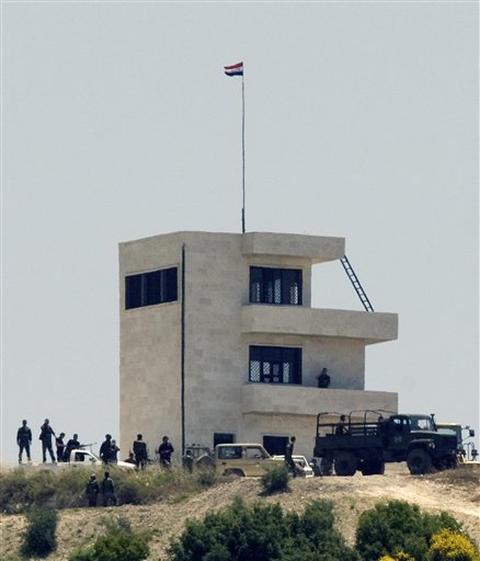 Syrian troops arrive at a hill overlooking Turkey-Syria border, about three kilometers inside Syria, as Syrians waiting to enter Turkey rush to the crossing point near the Turkish village of Guvecci in Hatay province, Turkey, Thursday, June 23, 2011. Syrian activists claimed that troops backed by tanks and snipers have entered a village along the Turkish border as the regime expands its crackdown on a pro-democracy movement that has posed the gravest challenge to President Bashar Assad's rule(AP Photo/Burhan Ozbilici) (AP)