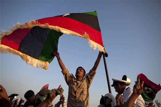 A new cadet for the Libyan rebel army holds a pre Moammar Gadhafi flag after a graduation ceremony for new cadets in Benghazi, Libya, Sunday, May 29, 2011.  (AP Photo/Rodrigo Abd) (AP)