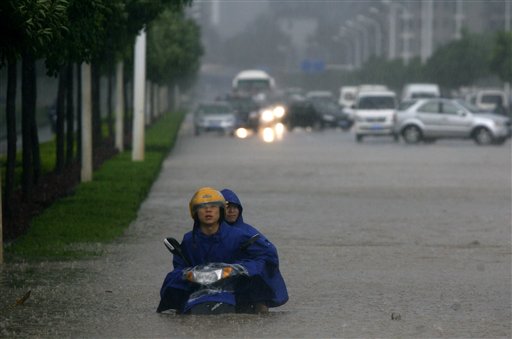 Two men on a motorcycle are stuck in floodwaters in Wuhan in central China's Hubei province Saturday June 18, 2011. Flooding from this month's seasonal rains has already forced hundreds of thousands of people from their homes and left more than 170 dead or missing. (AP Photo) CHINA OUT (AP)
