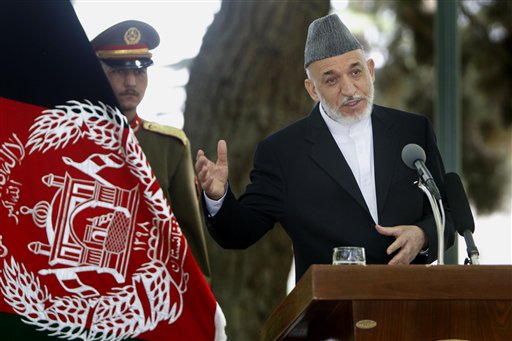 Afghan President Hamid Karzai, right,  addresses a joint press conference with NATO Secretary General Anders Fogh Rasmussen, unseen, as an Afghan Presidential bodyguard holds the Afghan flag, left, at the Presidential palace in Kabul, Afghanistan, Tuesday, May 24, 2011. NATO Secretary General Anders Fogh Rasmussen told journalists in Kabul that the "transition is on track" for the hand over of seven of Afghanistan's 34 provinces in July. Both Fogh Rasmussen and Afghan President Hamid Karzai urged insurgent fighters to lay down their weapons and embrace an ongoing peace process. (AP Photo/Mustafa Quraishi) (AP)