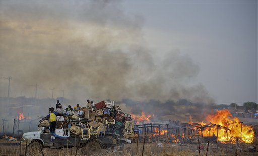 In this photo provided by the United Nations Mission in Sudan (UNMIS), a truck piled high with looted items drives past the burning huts of businesses and homesteads in the center of Abyei town, Sudan Saturday, May 28, 2011. Tens of thousands of Sudanese are fleeing from the contested north-south border region of Abyei, and the top U.S. official in the region warned Friday of a humanitarian crisis over the north's invasion. (AP Photo/UNMIS, Stuart Price) EDITORIAL USE ONLY, NO SALES (AP)