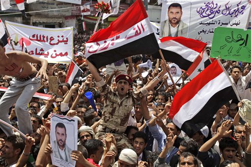 A Yemeni army soldier, center, lifted by anti-government protestors, reacts holding up his national flag with Arabic reads on it, " A thousand congratulations", as he and other demonstrators celebrate President Ali Abdullah Saleh's departure to Saudi Arabia, in Sanaa, Yemen, Sunday, June 5, 2011. Thousands of protesters are dancing and singing in the Yemeni capital Sanaa after the country's authoritarian leader flew to Saudi Arabia to receive medical treatment for wounds he suffered in a rocket attack on his compound. (AP Photo/Hani Mohammed) (AP)