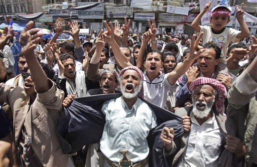 Anti-government protestors react during a demonstration demanding the resignation of Yemeni President Ali Abdullah Saleh, in Sanaa, Yemen, Monday, May 30, 2011. Yemeni warplanes carried out airstrikes Monday on a southern town seized by hundreds of Islamic militants over the weekend, witnesses said, as the political crisis surrounding the embattled president descended into more bloodshed. (AP Photo/Hani Mohammed) (AP)
