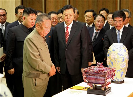In this photo released by China's Xinhua News Agency, North Korean leader Kim Jong Il, front left, looks at gifts presented to him by Chinese Vice Premier Zhang Dejiang, center, head of a Chinese delegation to celebrate the 50th anniversary of the Treaty of Friendship, Cooperation and Mutual Assistance Between China and Democratic People's Republic of Korea, in Pyongyang, North Korea, on Tuesday, July 12, 2011. Kim Jong Il's son Kim Jong Un stands behind his father. (AP Photo/Xinhua, Zhang Li) NO SALES (AP)