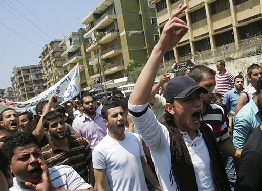 Lebanese anti-Syrian regime protesters shout slogans during a demonstration to support the Syrian demonstrators who protest in Syria against Bashar Assad's regime, in Tripoli, northern Lebanon, Friday July 1, 2011. Hundreds of thousands of protesters flooded cities around Syria on Friday in one of the largest outpourings against the regime of President Bashar Assad since the uprisings began more than three months ago. At least six people were killed in various clashes, activists said. (AP Photo) (AP)