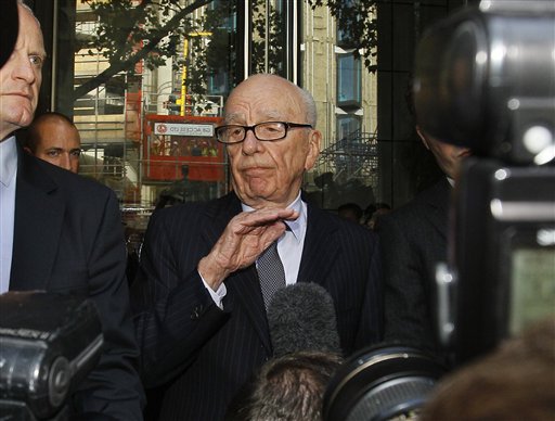 Rupert Murdoch, centre, attempts to speak to the media after he held a meeting with the parents and sister of murdered school girl Milly Dowler in London, Friday, July 15, 2011. The lawyer for the Milly Dowler's family says Rupert Murdoch has issued a full and sincere apology to the murdered schoolgirl's family for the actions of journalists at his newspaper. Mark Lewis told reporters that the media baron called the private meeting and apologized "many times," telling the Dowlers the events that transpired at the News of the World tabloid were not in keeping with the standards set out when his own father entered the media industry.(AP Photo/Kirsty Wigglesworth) (AP)