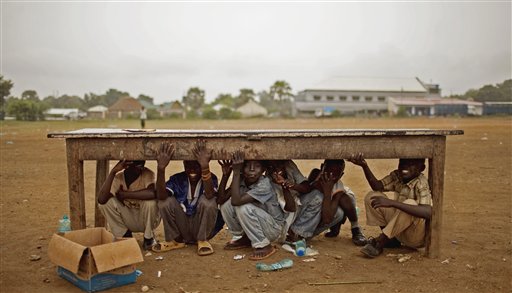 Southern Sudanese boys take shelter from afternoon rains that disrupted rehearsal for independence day celebrations in the capital city of Juba on Monday, July 4, 2011. (AP/Pete Muller)
