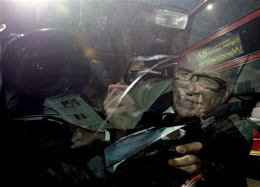 The scene is reflected in the car window as media mogul Rupert Murdoch is driven along Whitehall in central London, Tuesday, July 19, 2011.  Murdoch and his son James Murdoch are scheduled to be questioned by a parliamentary committee of British lawmakers Tuesday over the phone hacking scandal.  (AP Photo/Matt Dunham) (AP)