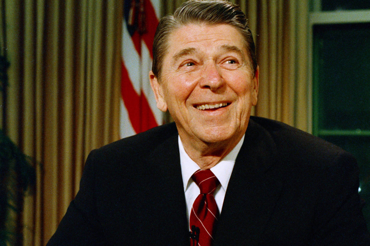 President Ronald Reagan smiles as he poses for photographers after delivering a speech on television, in this Dec. 11, 1987 file photo.