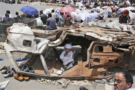 A Yemeni boy sits inside a wreckage of a car while anti-government protestors, attend Friday prayers, during a demonstration demanding the resignation of Yemeni President Ali Abduallah Saleh, in Taiz, Yemen, Friday, July 15, 2011. Tribesmen killed a Yemeni army officer and two of his aides in an ambush Friday, and government shelling killed two civilians in a volatile southern area, officials said. (AP Photo/Anees Mahyoub) (AP)