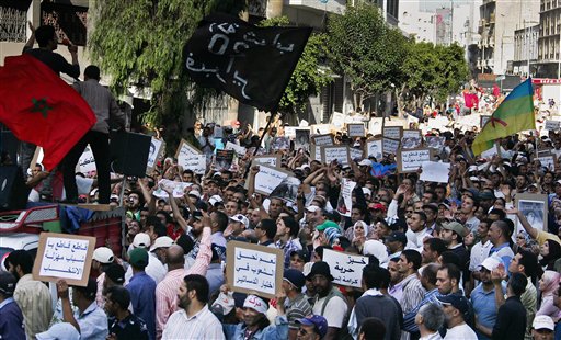 Thousands marched through Morocco's economic capital with various signs, including right "Bread, Freedom, Dignity and Human", right, "Yes people have to chose the constitution", center, and "Boycott, boycott ridicules election", left, during a rally organized by the 20th February, the Moroccan Arab Spring movement in Casablanca, Morocco, Sunday, June 12, 2011. Protesters called for greater democracy and an end to corruption even as the king prepares to unveil new constitutional amendments to address calls for reform. (AP Photo/Abdeljalil Bounhar) (AP)