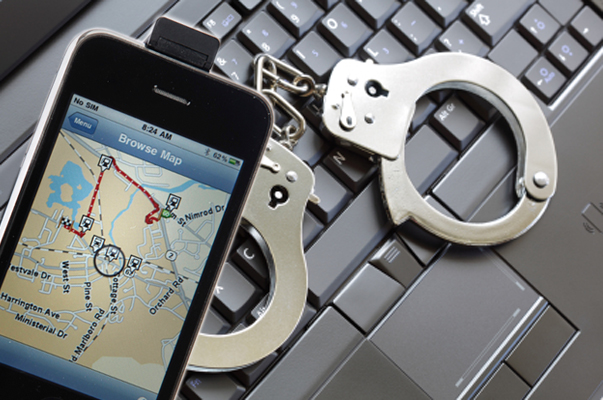 Online crime concept with handcuffs on latop keyboard
