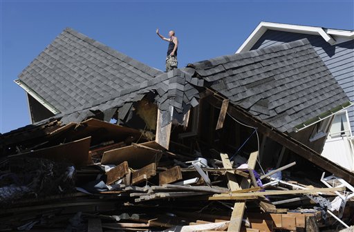 Tom Chase waves atop of his friend's beach home in the aftermath of Tropical Storm Irene, in East Haven, Conn., Monday, Aug. 29, 2011.  (AP Photo/Jessica Hill) (AP)