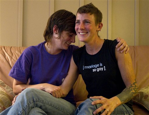 In a July 25, 2011 photo, lesbian couple Jennifer Tipton, left, and Olivier Odom are seen at a coffee house in Knoxville, Tenn. The couple are calling for Dollywood Splash County to be more inclusive to its guests after they were asked to reverse the pro-gay marriage T-shirt worn by Odom, during a recent visit.  (AP Photo/Knoxville News Sentinel, Saul Young) (AP)