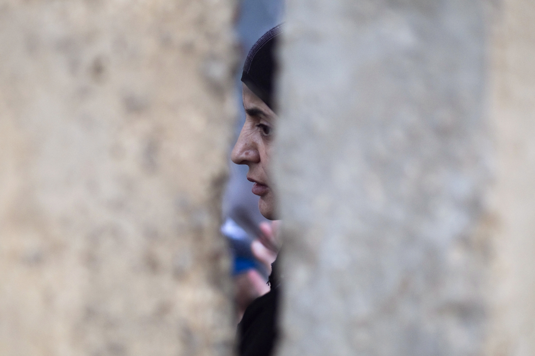 A Palestinian woman waits behind a wall after she was refused entry to cross into Jerusalem from Israel's Qalandiya checkpoint outside the West Bank city of Ramallah, during the third Friday of the holy month of Ramadan August 19, 2011. REUTERS/Darren Whiteside (WEST BANK - Tags: RELIGION POLITICS) (Â© Darren Whiteside / Reuters)