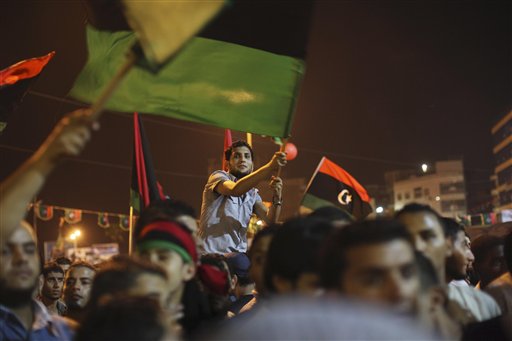 People celebrate the recent news of uprising in Tripoli against Moammar Gadhafi's regime at the rebel-held town of Benghazi, Libya, early Sunday, Aug. 21, 2011. Libyan rebels said they launched their first attack on Tripoli in coordination with NATO late Saturday, and Associated Press reporters heard unusually heavy gunfire and explosions in the capital. The fighting erupted just hours after opposition fighters captured the key city of Zawiya nearby. (AP Photo/Alexandre Meneghini) (AP)