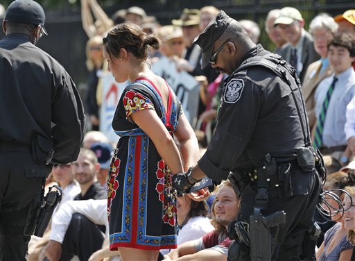 A U.S. Park Police officer handcuffs and arrests a protestor over a proposed pipeline to bring tar sands oil to the U.S. from Canada, in front of the White House in Washington, Saturday, Aug. 20, 2011.    (AP Photo/Manuel Balce Ceneta) (AP)