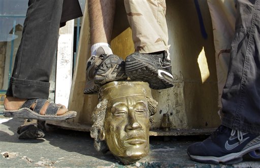 Rebel fighters trample on a head of Moammar Gadhafi inside the main compound in Bab al-Aziziya in Tripoli, LIbya, Tuesday, Aug. 23, 2011. Libyan rebels stormed Moammar Gadhafi's main military compound in Tripoli Tuesday after fierce fighting with forces loyal to his regime that rocked the capital as the longtime leader refused to surrender despite the stunning advances by opposition forces.  (AP Photo/Sergey Ponomarev) (AP)