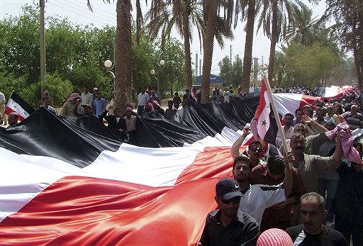 In this photo released by the Syrian official news agency SANA, Syrian pro-government supporters carry a giant national flag during a rally in the eastern province of Deir el-Zour, Syria, Thursday, July 28, 2011. A global campaigning organization said Thursday that one person disappears in Syria every hour and that almost 3,000 people have gone missing since the start of the uprising against President Bashar Assad more than four months ago. The online activist group Avaaz.org said its investigation has identified 2,918 Syrians who were arrested or abducted by force by security troops and whose whereabouts are now unknown. (AP Photo/SANA) EDITORIAL USE ONLY (AP)