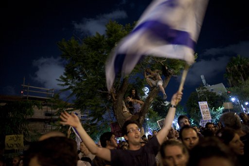 Thousands of Israelis march during a protest against the rising cost of living in Israel, in central Tel Aviv, Israel, Saturday, Aug. 6, 2011. Angry over the ever increasing cost of living, Israelis poured en masse into the streets of major cities Saturday night in a big show of force by the protest movement that is sweeping the country and proving to be a real challenge to Prime Minister Benjamin Netanyahu's government. Thousands of mostly middle class Israelis marched through the streets in central Tel Aviv waving flags, beating drums and chanting: "Social justice for the people." (AP Photo/Oded Balilty) (AP)