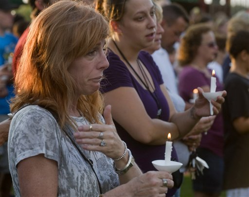 Bambi Lynn of Fairlawn, Ohio, wipes away tears during a prayer vigil at Copley Community Park in Copley Township, Ohio, Sunday, Aug. 7, 2011. A man gunned down two people outside an Ohio home and two more in a car Sunday morning, then shot his girlfriend in a rampage that left eight dead including the gunman, who was shot by police, authorities and witnesses said. Lynn is fearful that one of the victims is a co-worker. (AP Photo/Phil Long) (AP)