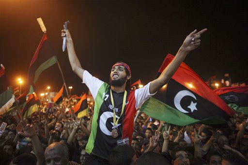 People celebrate the capture in Tripoli of Moammar Gadhafi's son and one-time heir apparent, Seif al-Islam, at the rebel-held town of Benghazi, Libya, early Monday, Aug. 22, 2011. Libyan rebels raced into Tripoli in a lightning advance Sunday that met little resistance as Moammar Gadhafi's defenders melted away and his 40-year rule appeared to rapidly crumble. The euphoric fighters celebrated with residents of the capital in the city's main square, the symbolic heart of the regime. (AP Photo/Alexandre Meneghini) (AP)